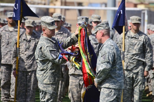U.S. Army Lt. Col. Robert Magee and U.S. Army Command Sgt. Maj. Clinton Reiss uncase the 1st Combined Arms Battalion, 18th Infantry Regiment, 2nd Armored Brigade Combat Team, 1st Infantry Division battalion colors during a transfer of authority ceremony at Camp Lemonnier, Djibouti, Dec. 14, 2013.