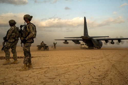 Soldiers of the 1st Battalion, 18th Infantry Regiment, assigned to the East Africa Response Force, provide security as pararescuemen of the 82d Expeditionary Rescue Squadron (ERQS) return to an HC-130 of the 81st ERQS during a training exercise on January 12th, 2014.